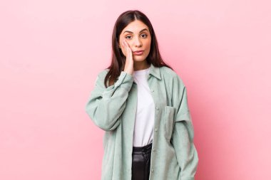 Genç, güzel bir kadın, ağzı açık bir şekilde yüz yüze inanmayarak şok olmuş ve hayrete düşmüş hissediyor.