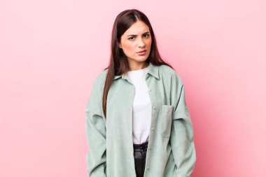 Genç, güzel bir kadın şaşkın ve şaşkın hissediyor, aptal, sersemlemiş bir ifadeyle beklenmedik bir şeye bakıyor.