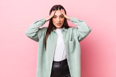 Genç ve güzel bir kadın el ele tutuşuyor, ağzı açık, son derece şanslı, şaşırmış, heyecanlı ve mutlu hissediyor.