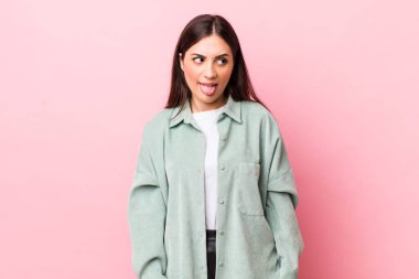 Genç ve güzel bir kadın, tiksinmiş ve rahatsız olmuş hissediyor. Dilini dışarı çıkarıyor, iğrenç ve iğrenç bir şeyden hoşlanmıyor.