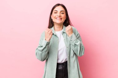 Genç ve güzel bir kadın zaferle bağırıyor, gülüyor, mutlu ve heyecanlı hissediyor başarıyı kutlarken.