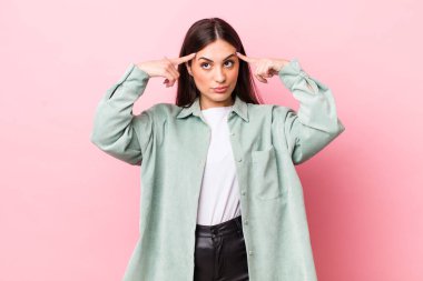 Ciddi ve konsantre görünümlü genç ve güzel bir kadın, beyin fırtınası yapıyor ve zorlu bir sorunu düşünüyor.