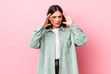 Genç ve güzel bir kadın ellerini havaya kaldırarak bağırıyor. Öfkeli, sinirli, stresli ve üzgün.