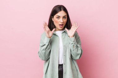 Genç ve güzel bir kadın beklenmedik bir sürpriz yüzünden şaşkın, heyecanlı, gülen, şaşkın ve mutlu hissediyor.