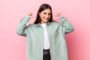 Genç, güzel bir kadın gururlu, kibirli ve kendinden emin, tatmin olmuş ve başarılı görünüyor, kendini işaret ediyor.