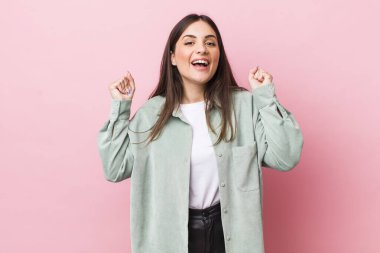 Genç ve güzel bir kadın öfkeli bir ifadeyle ya da yumruklarıyla başarıyı kutlarken agresif bir şekilde bağırıyor.