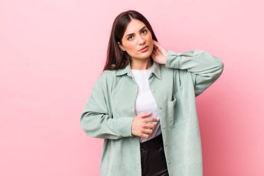 Genç ve güzel bir kadın stresli, hayal kırıklığına uğramış ve yorgun, endişeli ve sorunlu bir bakışla boynunu ovalıyor.