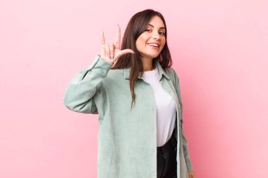 Genç, güzel bir kadın kendini mutlu, eğlenceli, kendinden emin, pozitif ve asi hissediyor, elle rock ya da heavy metal işareti yapıyor.