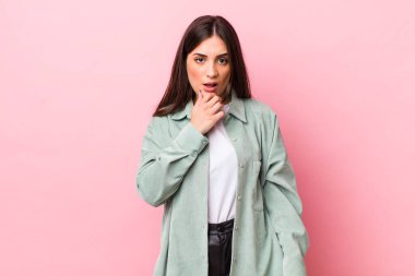 Ağzı ve gözleri açık, eli çenesinde genç ve güzel bir kadın. Hoş olmayan bir şok geçiriyor.