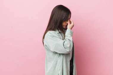 Genç ve güzel bir kadın stresli, mutsuz ve hayal kırıklığına uğramış, alnına dokunuyor ve şiddetli baş ağrısı çekiyor.