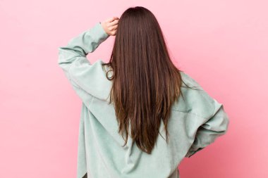 Genç, güzel bir kadın bilgisiz ve kafası karışık hissediyor, bir çözüm düşünüyor, eli kalçasında, diğeri kafasında, dikiz aynasından.