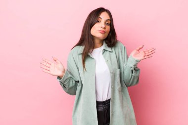 Genç ve güzel bir kadın şaşkın ve şaşkın hissediyor, doğru cevap ya da karardan emin değil, bir seçim yapmaya çalışıyor.