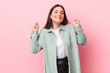 Genç, güzel bir kadın mutlu, pozitif ve başarılı hissediyor, zaferi, başarıları ya da iyi şansı kutluyor.