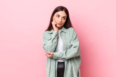 Genç, güzel bir kadın düşünceli, meraklı ya da hayal kuruyor, hayal kuruyor ve gökyüzüne bakıyor.