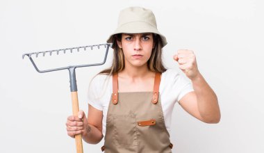 young adult pretty woman. farmer with a rake concept