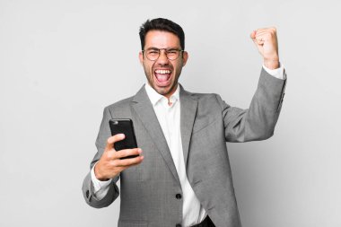 Genç, yakışıklı, İspanyol bir adamın cep telefonuyla yaptığı iş konsepti.