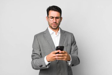 Genç, yakışıklı, İspanyol bir adamın cep telefonuyla yaptığı iş konsepti.