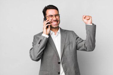 Genç, yakışıklı, İspanyol bir adamın cep telefonuyla yaptığı iş konsepti.