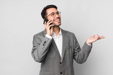 Genç, yakışıklı, İspanyol bir adamın cep telefonuyla yaptığı iş konsepti.