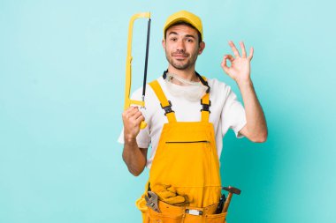 young adult man. handyman with a saw concept