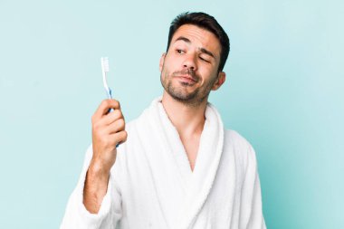 Genç İspanyol adam. Bornoz ve diş fırçası konsepti