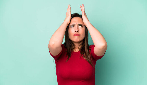 молодая взрослая красивая женщина чувствует стресс и тревогу, депрессию и разочарование от головной боли, поднимая обе руки к голове