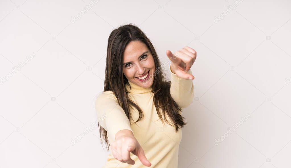 young adult pretty woman feeling happy and confident, pointing to camera with both hands and laughing, choosing you