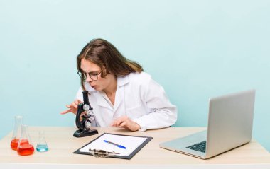 young physician woman with a microscophe. sciencist concept