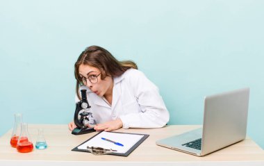 young physician woman with a microscophe. sciencist concept