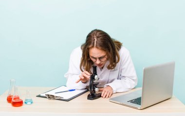young physician woman with a microscophe. sciencist concept