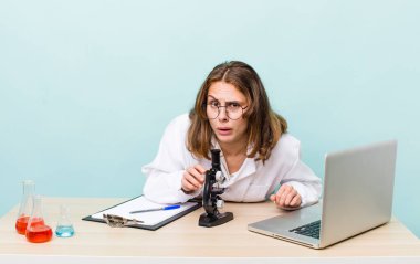 young physician woman with a microscophe. sciencist concept