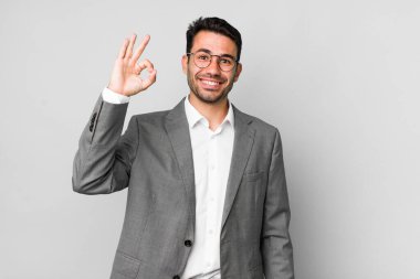 Genç, Latin asıllı bir adam kendini mutlu hissediyor. Onayını iyi bir hareketle gösteriyor. iş kavramı