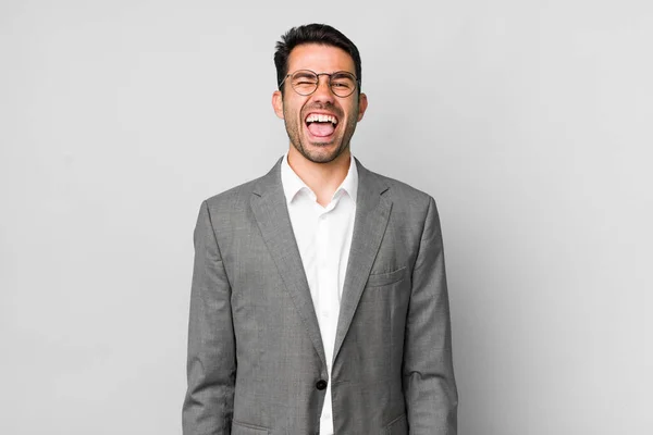 陽気で反抗的な態度を持つ若い大人のヒスパニック系の男冗談と舌を突き出す ビジネスコンセプト — ストック写真