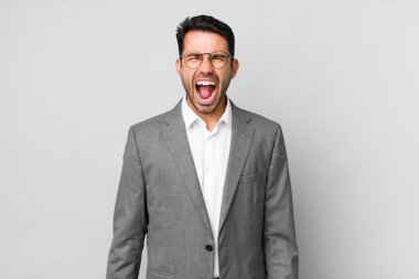 Genç, Latin asıllı bir adam agresif bir şekilde bağırıyor, çok kızgın görünüyor. iş kavramı