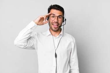 Genç, İspanyol bir adam mutlu, şaşkın ve şaşırmış görünüyor. tele pazarlamacı kavramı