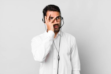 Genç, Latin asıllı bir adam bıkkın, bıkkın ve uykulu hissediyor. tele pazarlamacı kavramı