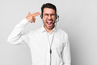 Genç, Latin asıllı, mutsuz ve stresli bir adam, intihar işareti yapıyor. tele pazarlamacı kavramı