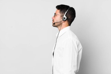 Profil görünümlü genç, İspanyol bir adam hayal kuruyor, hayal görüyor ya da hayal görüyor. tele pazarlamacı kavramı