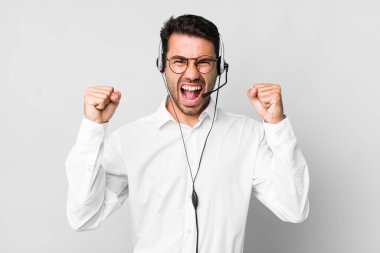 Genç, Latin bir adam öfkeli bir ifadeyle agresif bir şekilde bağırıyor. tele pazarlamacı kavramı