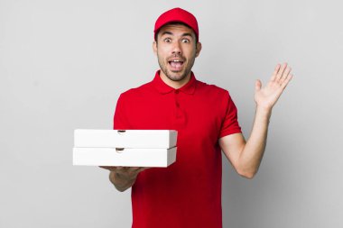 Genç, İspanyol bir adam inanılmaz bir şey karşısında mutlu ve şaşkın hissediyor. Pizza teslimatı kavramı
