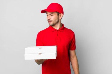 Profil görünümlü genç, İspanyol bir adam hayal kuruyor, hayal görüyor ya da hayal görüyor. Pizza teslimatı kavramı