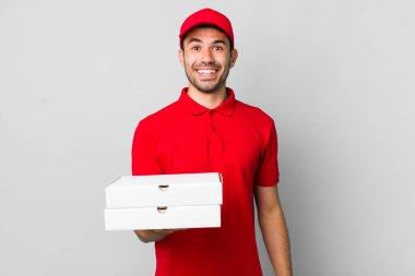 Genç, İspanyol bir adam mutlu ve hoş bir şekilde şaşırmış görünüyor. Pizza teslimatı kavramı