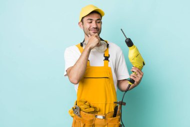 Mutlu, kendinden emin, elleri çenesinde gülümseyen genç bir İspanyol. işçi ve sondaj kavramı