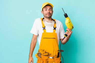 Genç, İspanyol bir adam omuz silkiyor, kafası karışık ve kararsız. işçi ve sondaj kavramı