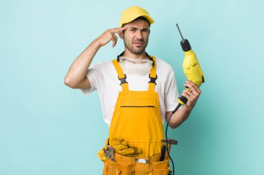 Genç, İspanyol bir adam kafası karışık ve şaşkın hissediyor, senin deli olduğunu gösteriyor. işçi ve sondaj kavramı