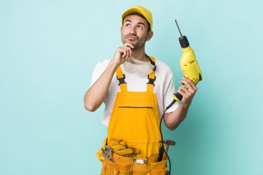 Genç, İspanyol bir adam düşünüyor, kuşkulu ve şaşkın hissediyor. işçi ve sondaj kavramı