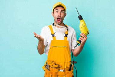 Genç, yetişkin İspanyol bir adam son derece şaşırmış ve şok olmuş hissediyor. işçi ve sondaj kavramı