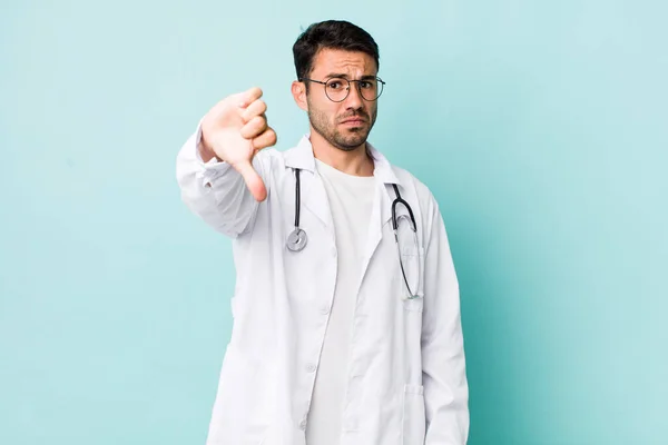 Young Adult Hispanic Man Feeling Cross Showing Thumbs Physician Concept — 스톡 사진