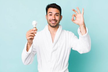 Genç, Latin asıllı bir adam kendini mutlu hissediyor. Onayını iyi bir hareketle gösteriyor. traş konsepti
