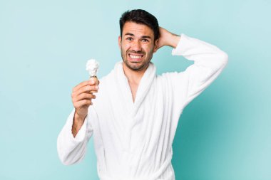 Genç, İspanyol bir adam stresli, endişeli ya da korkmuş hissediyor. Elleri başının üstünde. traş konsepti